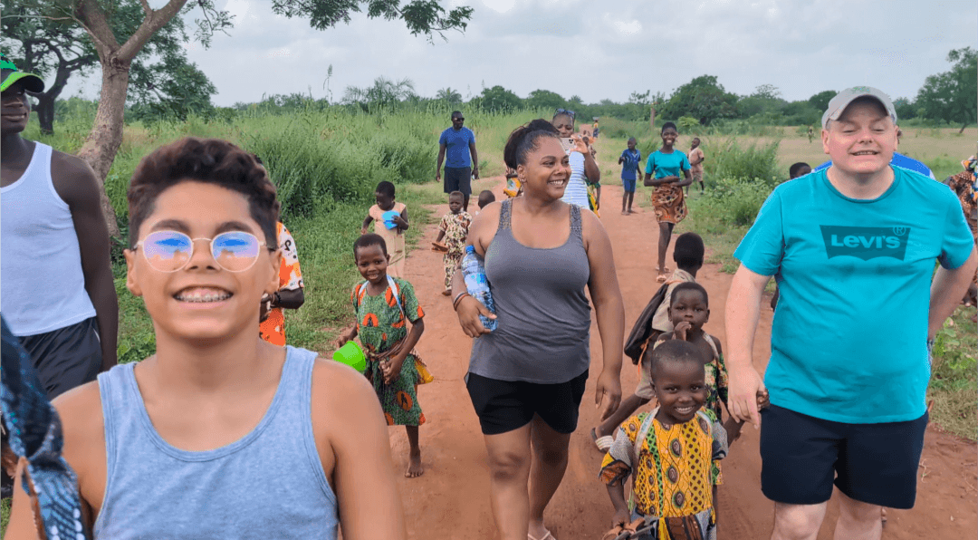 Voyageurs et villageois marchant ensemble sur la piste