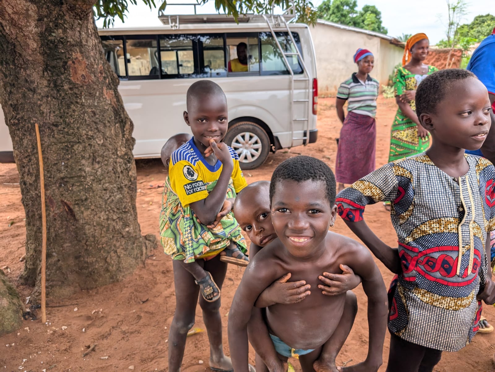 Enfants rassemblés près d'un véhicule au village